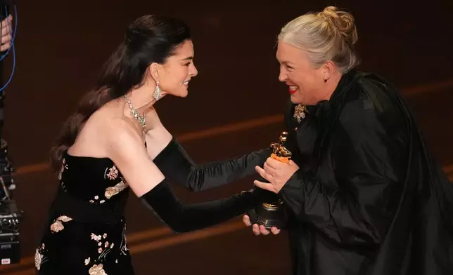 Anne Hathaway presents the award for best costume design to Kate Hawley for "Frankenstein" during the Oscars on Sunday, March 15, 2026, at the Dolby Theatre in Los Angeles. (AP Photo/Chris Pizzello)