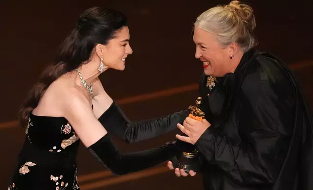 Anne Hathaway presents the award for best costume design to Kate Hawley for "Frankenstein" during the Oscars on Sunday, March 15, 2026, at the Dolby Theatre in Los Angeles. (AP Photo/Chris Pizzello)