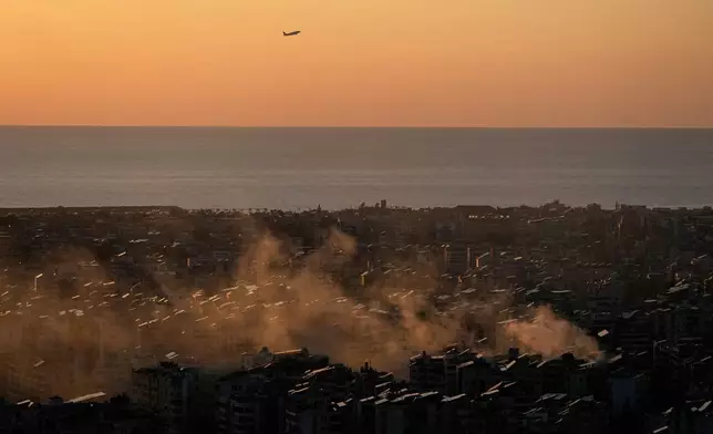 A plane takes off from the Beirut–Rafic Hariri International Airport as smoke from an earlier Israeli airstrike still rises in Dahiyeh, Beirut's southern suburbs, Lebanon, Thursday, March 5, 2026.(AP Photo/Hussein Malla)