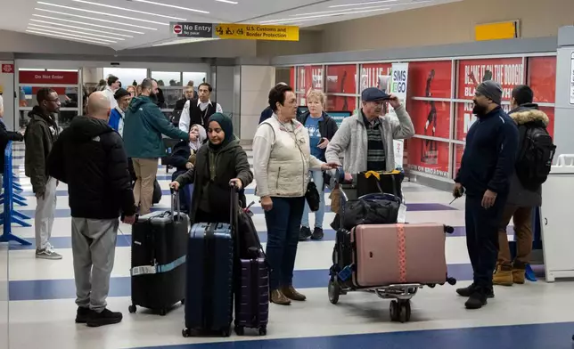 People walk out of the terminal upon their arrival from Amman, Jordan at John F. Kennedy International Airport in New York, Thursday, March 5, 2026. (AP Photo/Yuki Iwamura)