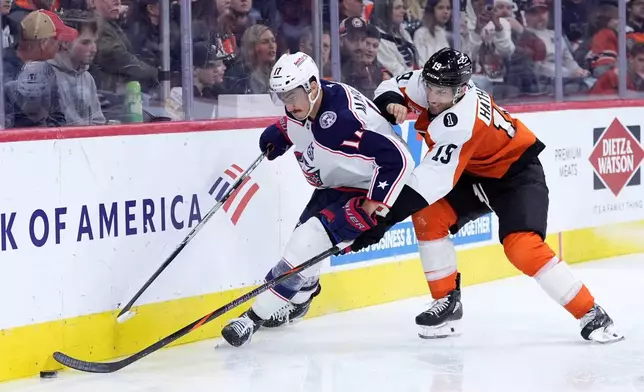 Columbus Blue Jackets' Mason Marchment, left, and Philadelphia Flyers' Garnet Hathaway battle for the puck during the second period of an NHL hockey game Tuesday, March 24, 2026, in Philadelphia. (AP Photo/Matt Slocum)