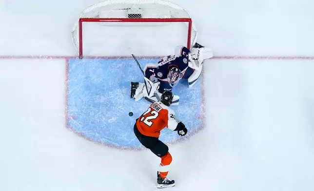 Philadelphia Flyers' Christian Dvorak, bottom, can not get a shot past Columbus Blue Jackets' Jet Greaves during the second period of an NHL hockey game Tuesday, March 24, 2026, in Philadelphia. (AP Photo/Matt Slocum)