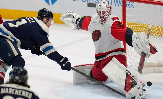 Columbus Blue Jackets' Charlie Coyle (3) scores on Carolina Hurricanes goalie Brandon Bussi, right, in the first period of an NHL hockey game in Columbus, Tuesday, March 17, 2026. (AP Photo/Sue Ogrocki)
