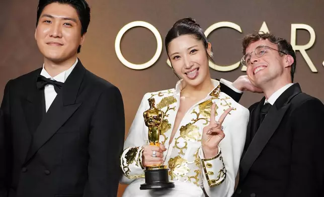Joong Gyu Kwak, from left, EJAE, and Mark Sonnenblick, winners of the award for music (original song) for "Golden" from "K-pop Demon Hunters," pose in the press room at the Oscars on Sunday, March 15, 2026, at the Dolby Theatre in Los Angeles. (Photo by Jordan Strauss/Invision/AP)