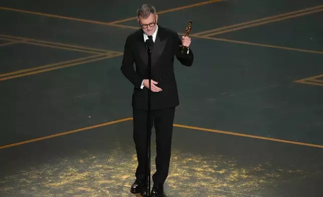 Paul Thomas Anderson accepts the award for writing (adapted screenplay) for "One Battle After Another" during the Oscars on Sunday, March 15, 2026, at the Dolby Theatre in Los Angeles. (AP Photo/Chris Pizzello)