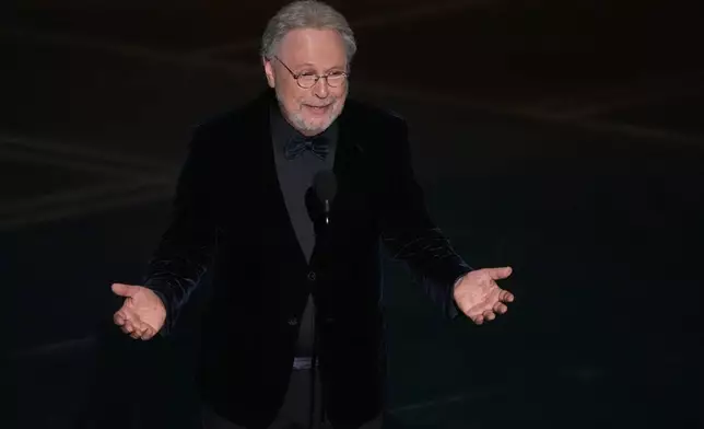 CORRECTS SPELLING OF MICHELE- Billy Crystal presents a tribute about Rob Reiner and Michele Singer Reiner during the Oscars on Sunday, March 15, 2026, at the Dolby Theatre in Los Angeles. (AP Photo/Chris Pizzello)