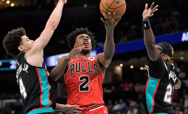 Chicago Bulls guard Collin Sexton (2) shoots between Memphis Grizzlies guards Walter Clayton Jr. (4) and Jahmai Mashack, right, in the first half of an NBA basketball game Saturday, March 28, 2026, in Memphis, Tenn. (AP Photo/Brandon Dill)