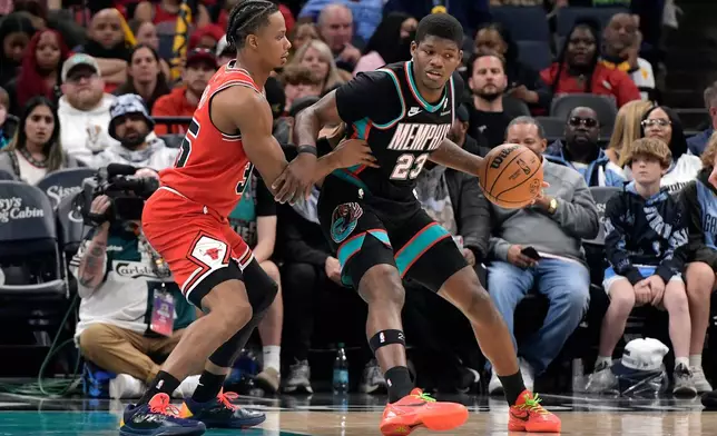 Memphis Grizzlies forward Cedric Coward (23) handles the ball against Chicago Bulls forward Isaac Okoro (35) in the first half of an NBA basketball game Saturday, March 28, 2026, in Memphis, Tenn. (AP Photo/Brandon Dill)