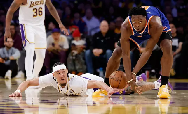 Los Angeles Lakers center Jaxson Hayes, bottom, and New York Knicks forward Og Anunoby, right, fight for possession of the ball during the first half of an NBA basketball game, Sunday, March 8, 2026, in Los Angeles. (AP Photo/Caroline Brehman)