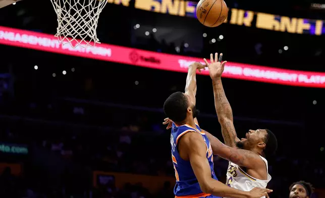 Los Angeles Lakers guard Marcus Smart, right, drives to the basket with the ball while being guarded by New York Knicks guard Mikal Bridgesduring the first half of an NBA basketball game Sunday, March 8, 2026, in Los Angeles. (AP Photo/Caroline Brehman)