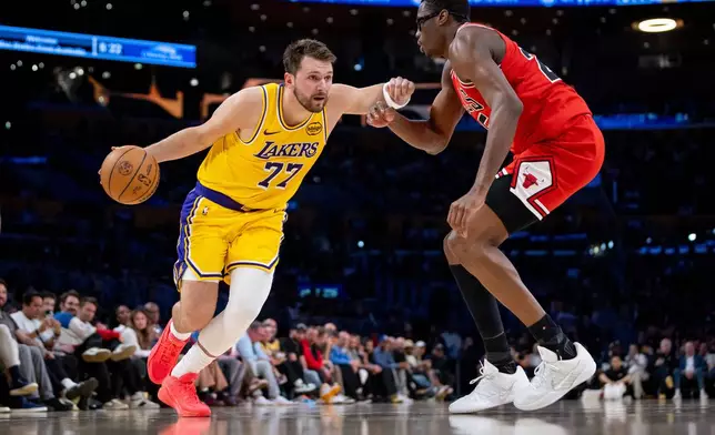 Los Angeles Lakers guard Luka Doncic (77) is defended by Chicago Bulls forward Jalen Smith, right, during the first half of an NBA basketball game against the Chicago Bulls, Thursday, March 12, 2026, in Los Angeles. (AP Photo/Ethan Swope)