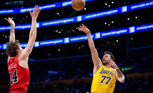 Los Angeles Lakers guard Luka Doncic (77) shoots against Chicago Bulls forward Matas Buzelis (14) during the first half of an NBA basketball game against the Chicago Bulls, Thursday, March 12, 2026, in Los Angeles. (AP Photo/Ethan Swope)