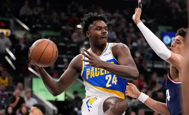 Indiana Pacers guard Kobe Brown, left, passes while under pressure from Los Angeles Clippers center Yanic Konan Niederhauser during the first half of an NBA basketball game Wednesday, March 4, 2026, in Inglewood, Calif. (AP Photo/Mark J. Terrill)