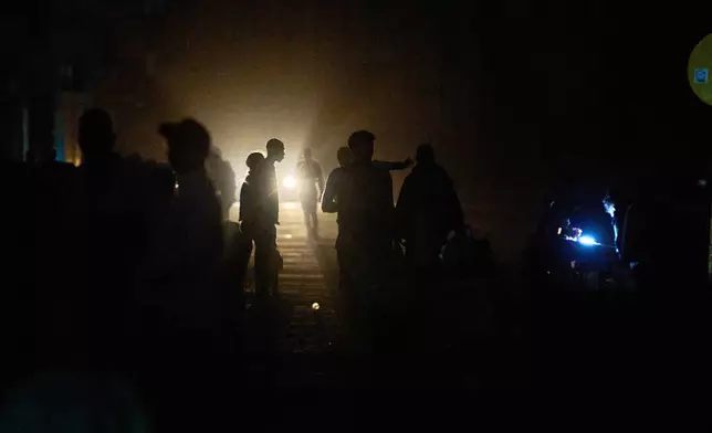 People walk on a street in the dark during a blackout in Havana, Cuba, Saturday, March 21, 2026. (AP Photo/Ramon Espinosa)