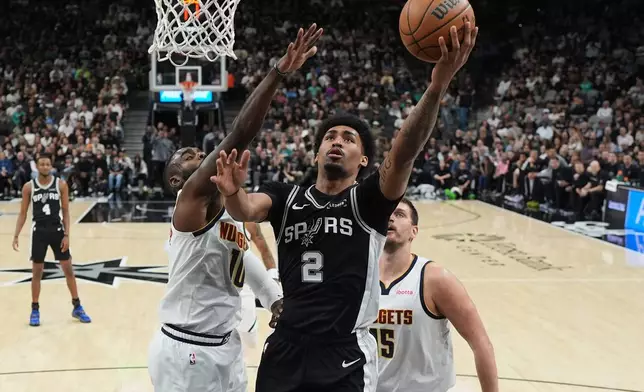 San Antonio Spurs guard Dylan Harper (2) drives to the basket against Denver Nuggets guard Tim Hardaway Jr. (10) during the first half of an NBA basketball game in San Antonio, Thursday, March 12, 2026. (AP Photo/Eric Gay)