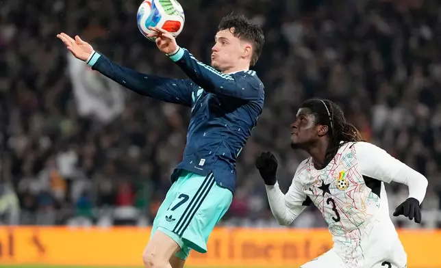 Florian Wirtz of Germany and Caleb Yirenkyi of Ghana challenge for the ball during an international friendly soccer match between Germany and Ghana in Stuttgart, Germany, Monday, March 30, 2026. (AP Photo/Matthias Schrader)