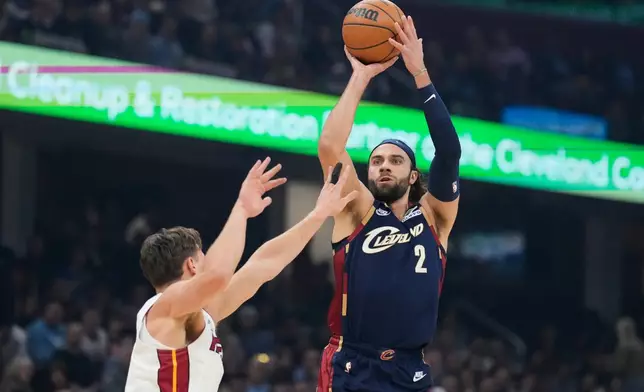 Cleveland Cavaliers guard Max Strus (2) shoots over Miami Heat guard Pelle Larsson, left, in the first half of an NBA basketball game in Cleveland, Friday, March 27, 2026. (AP Photo/Sue Ogrocki)