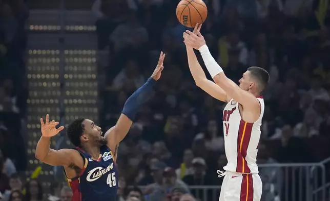 Miami Heat guard Tyler Herro, right, shoots over Cleveland Cavaliers guard Donovan Mitchell (45) in the first half of an NBA basketball game in Cleveland, Friday, March 27, 2026. (AP Photo/Sue Ogrocki)