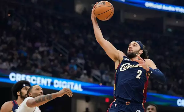 Cleveland Cavaliers guard Max Strus (2) goes up for a shot in front of Miami Heat guard Norman Powell, left, in the first half of an NBA basketball game in Cleveland, Friday, March 27, 2026. (AP Photo/Sue Ogrocki)