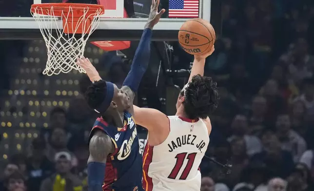 Miami Heat forward Jaime Jaquez Jr. (11) shoots as Cleveland Cavaliers guard Dennis Schroder, left, defends in the first half of an NBA basketball game in Cleveland, Friday, March 27, 2026. (AP Photo/Sue Ogrocki)