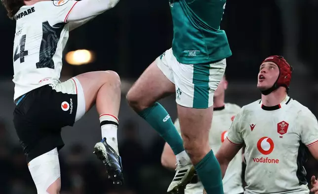 Ireland's Jacob Stockdale, right, compete to catch the ball with Wales' Ellis Mee during a Six Nations rugby union match between Ireland and Wales in Dublin, Ireland, Friday, March 6, 2026. (AP Photo/Peter Morrison)