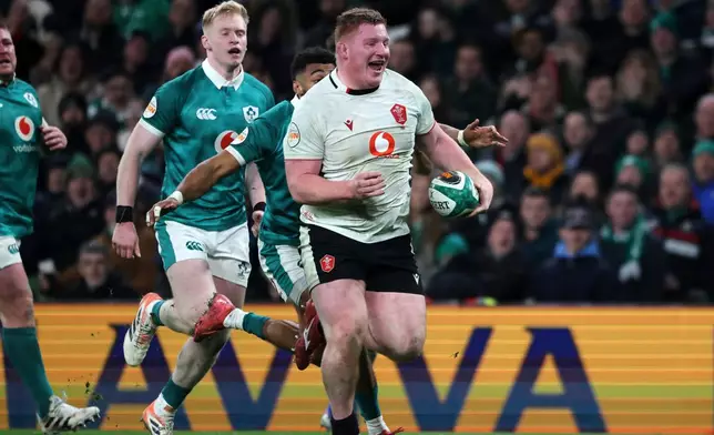 Wales' Rhys Carre, front, breaks through to score his team's first try during a Six Nations rugby union match between Ireland and Wales in Dublin, Ireland, Friday, March 6, 2026. (AP Photo/Peter Morrison)