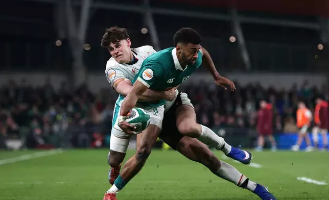 Ireland's Robert Baloucoune, right, is tackled by Wales' Eddie James during a Six Nations rugby union match between Ireland and Wales in Dublin, Ireland, Friday, March 6, 2026. (AP Photo/Peter Morrison)