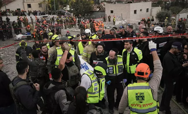 FILE - Rescue workers and military personnel carry a body of a victim from the scene where several people were killed by an Iranian missile strike in Beit Shemesh, Israel, Sunday, March 1, 2026. (AP Photo/Leo Correa, File)