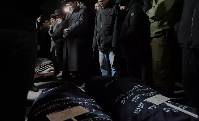 FILE - Mourners attend the funeral of Yaakov Biton, 16, and his two sisters, Avigail, 15, and Sarah, 13, who were killed in an Iranian missile attack, at the cemetery in Mount of Olives in Jerusalem, Monday, March 2, 2026. (AP Photo/Mahmoud Illean, File)