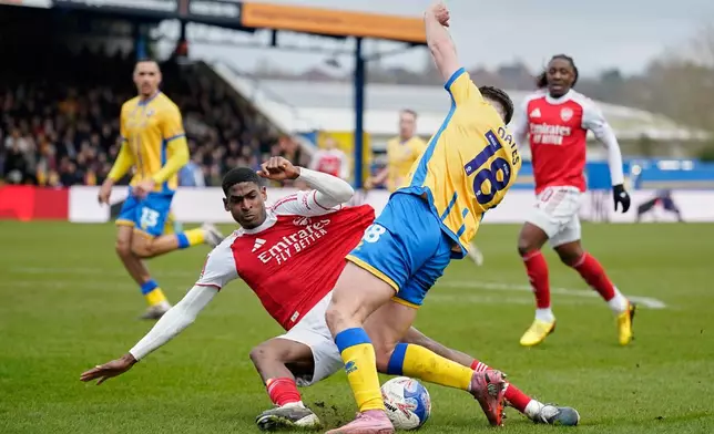 Arsenal's Cristhian Mosquera, left, challenges for the ball with Mansfield's Rhys Oates during the English FA Cup soccer match between Mansfield Town and Arsenal in Mansfield, England, Saturday, March 7, 2026.(AP Photo/Dave Thompson)