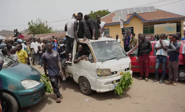 People gather at the scene of Sunday night's gunmen attack in Gari Ya Waye community in the Jos North Nigeria, Monday, March 30, 2026. (AP Photo/Samson Omale)