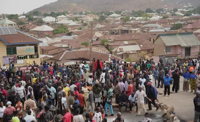 People gather at the scene of Sunday night gunmen attack in Gari Ya Waye community in the Jos North Nigeria, Monday, March 30, 2026. (AP Photo/Samson Omale)