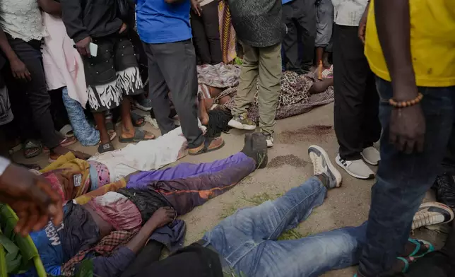 People gather around bodies of a gunmen attack victims in Gari Ya Waye community in Jos North Nigeria, Monday, March 30, 2026. (AP Photo/Samson Omale)