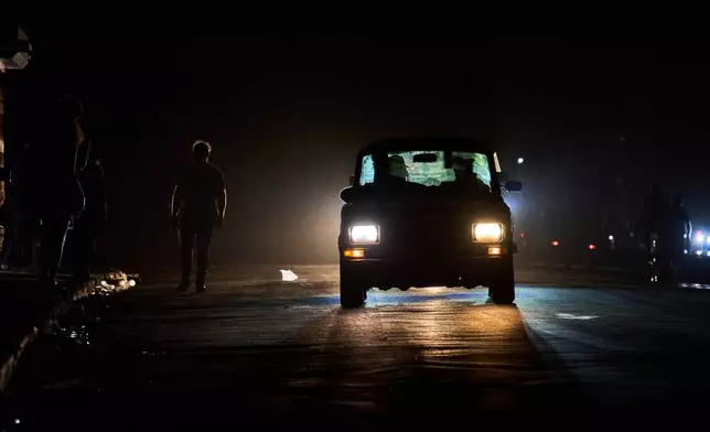 A vehicle drives down a street during a blackout in Havana, Wednesday, March 4, 2026. (AP Photo/Ramon Espinosa)