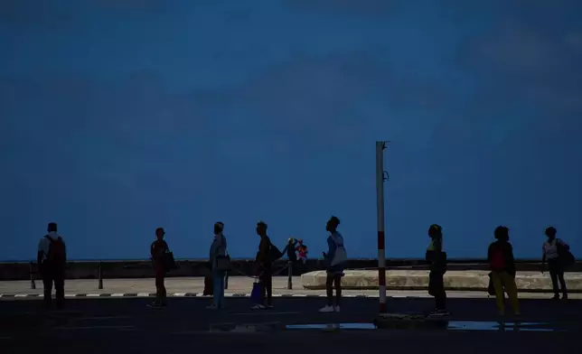 People wait to take public transportation during a blackout in Havana, Wednesday, March 4, 2026. (AP Photo/Ramon Espinosa)