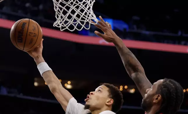 Milwaukee Bucks guard Ryan Rollins (13) drives to the basket with the ball while being guarded by LA Clippers forward Kawhi Leonard (2) during the first half of an NBA basketball game Monday, March 23, 2026, in Inglewood, Calif. (AP Photo/Caroline Brehman)