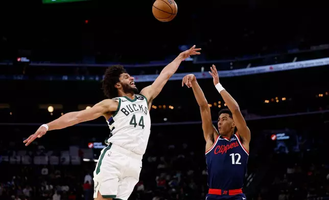 LA Clippers guard Cam Christie (12) takes a shot while being guarded by Milwaukee Bucks guard Andre Jackson Jr. (44) during the second half of an NBA basketball game Monday, March 23, 2026, in Inglewood, Calif. (AP Photo/Caroline Brehman)