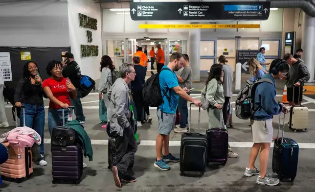 Airline passengers wait in long lines outside the terminal to get through the TSA security screening at William P. Hobby Airport in Houston, Sunday, March 8, 2026. (Brett Coomer/Houston Chronicle via AP)