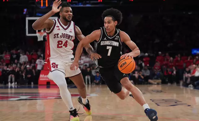 Georgetown Hoyas' Isaiah Abraham (7) drives past St. John's Red Storm's Zuby Ejiofor (24) during the first half of an NCAA college basketball game Tuesday, March 3, 2026, in New York. (AP Photo/Frank Franklin II)