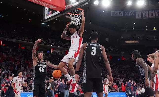 St. John's Red Storm's Dillon Mitchell (1) dunks the ball in front of Georgetown Hoyas' Kayvaun Mulready (45) and Vincent Iwuchukwu (3) during the second half of an NCAA college basketball game Tuesday, March 3, 2026, in New York. (AP Photo/Frank Franklin II)