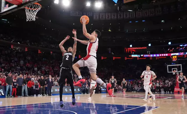 St. John's Red Storm's Dylan Darling (0) drives past Georgetown Hoyas' Malik Mack (2) during the second half of an NCAA college basketball game Tuesday, March 3, 2026, in New York. (AP Photo/Frank Franklin II)