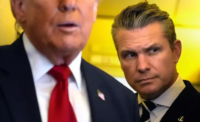 Defense Secretary Pete Hegseth listens as President Donald Trump speaks to reporters while traveling aboard Air Force One en route from Dover Air Force Base, Del., to Miami, Saturday, March 7, 2026. (AP Photo/Mark Schiefelbein)