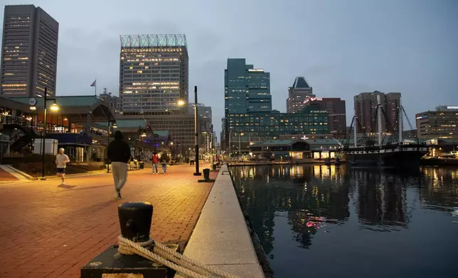 People walk around Baltimore's Inner Harbor on March 5, 2026. (AP Photo/Michael Phillis)