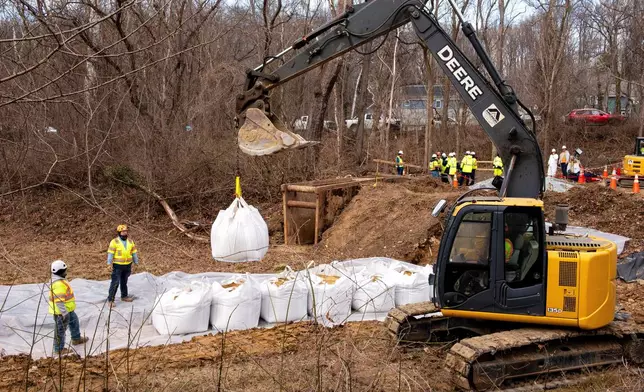 Workers build a cofferdam to stop the flow of raw sewage into the Potomac River after a massive sewage pipe rupture in Glen Echo, Md., Friday, Jan. 23, 2026. (AP Photo/Cliff Owen)