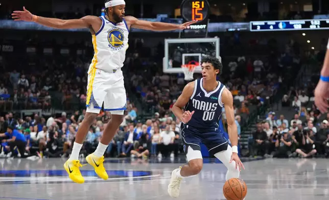 Dallas Mavericks guard Max Christie (00) prepares to shoot a basket as Golden State Warriors guard Moses Moody (4) defends during overtime of an NBA basketball game Monday, March 23, 2026, in Dallas. (AP Photo/Julio Cortez)
