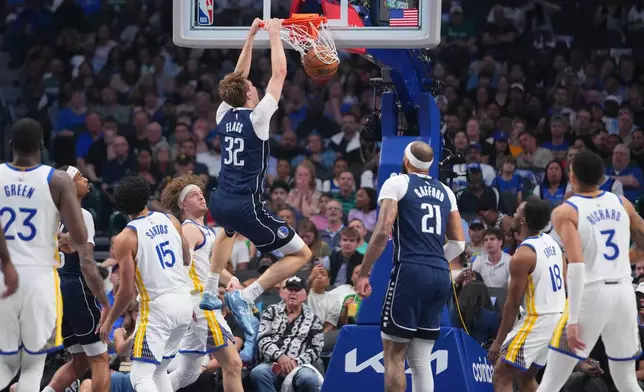 Dallas Mavericks forward Cooper Flagg (32) dunks on the Golden State Warriors during the first half of an NBA basketball game Monday, March 23, 2026, in Dallas. (AP Photo/Julio Cortez)