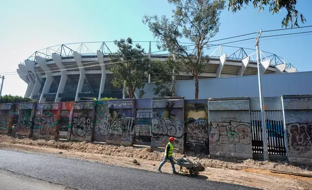 A worker pushes a wheelbarrow outside of the Azteca Stadium, 100 days before the opening ceremony of the FIFA soccer World Cup 2026 in Mexico City, Tuesday, March 3, 2026. (AP Photo/Fernando Llano)
