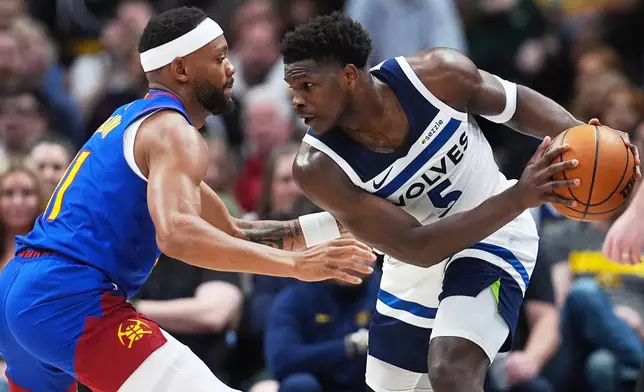 Minnesota Timberwolves guard Anthony Edwards, right, looks to move to the rim as Denver Nuggets guard Bruce Brown defends in the first half of an NBA basketball game, Sunday, March 1, 2026, in Denver. (AP Photo/David Zalubowski)