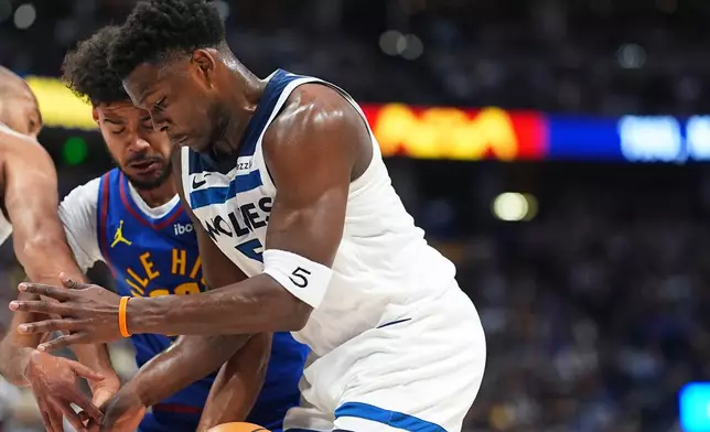 Minnesota Timberwolves guard Anthony Edwards, front, struggles to control the ball as Denver Nuggets forward Cameron Johnson defends in the first half of an NBA basketball game Sunday, March 1, 2026, in Denver. (AP Photo/David Zalubowski)
