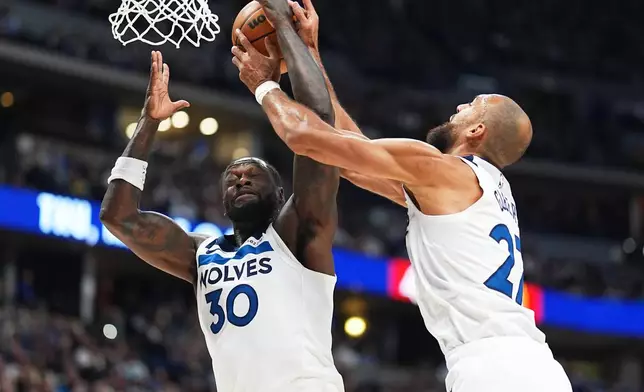 Minnesota Timberwolves forward Julius Randle, left, fights for control of a rebound with center Rudy Gobert in the first half of an NBA basketball game against the Denver Nuggets, Sunday, March 1, 2026, in Denver. (AP Photo/David Zalubowski)